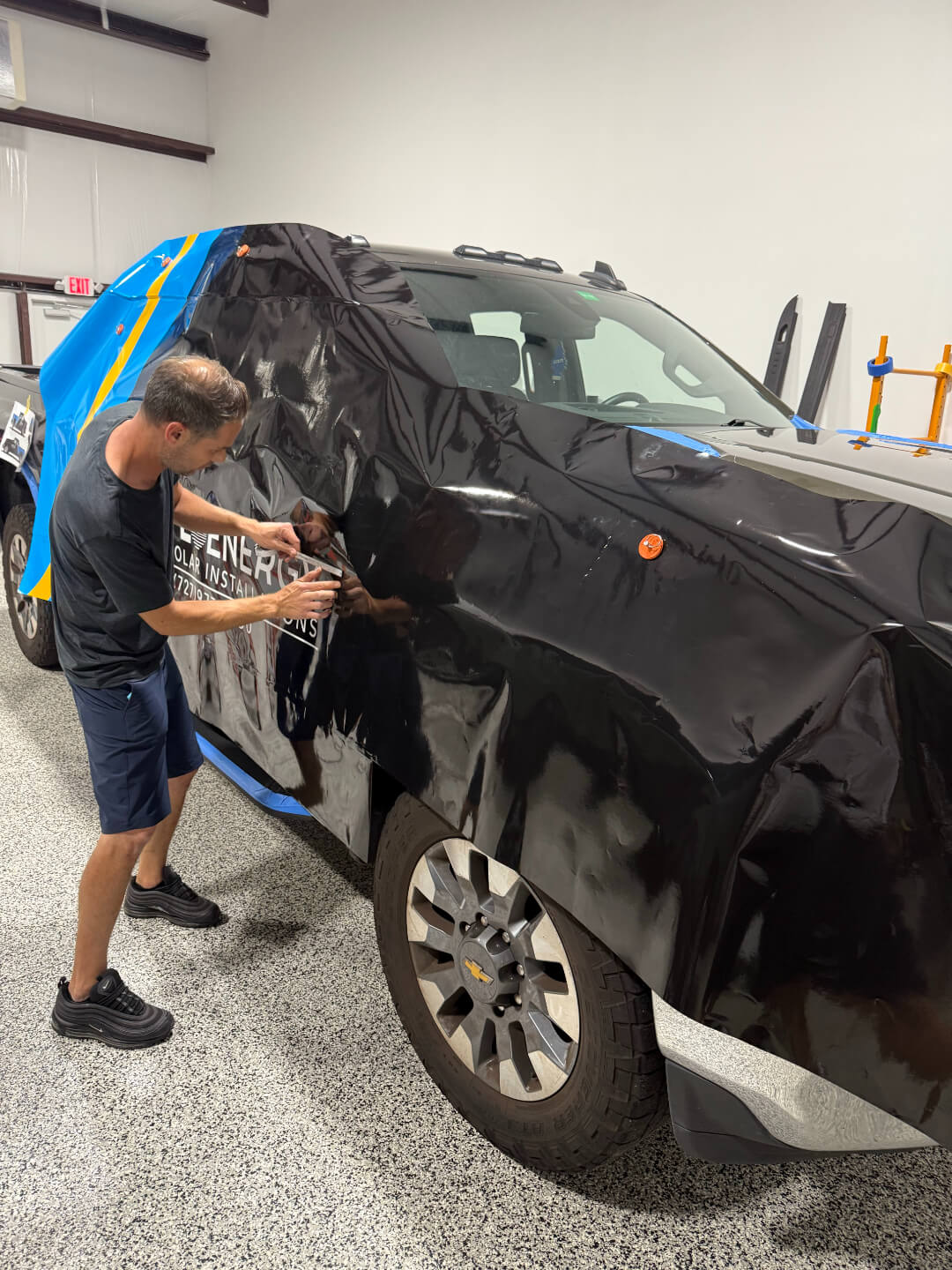 one man putting sticker on the car